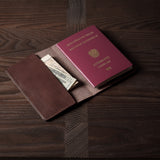 Brown leather passport case on a wooden surface