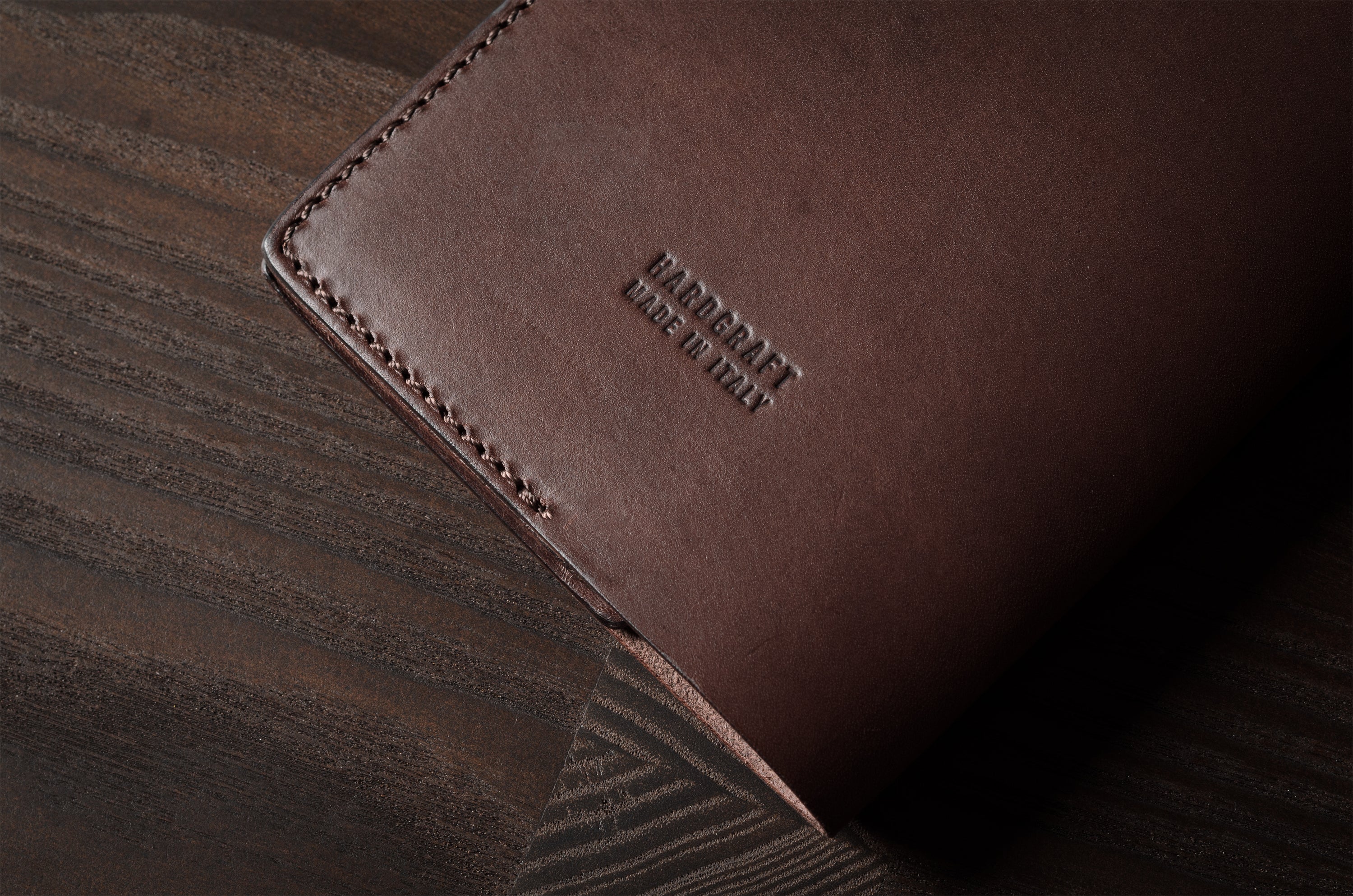 Brown leather passport case on a wooden surface