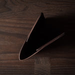 Brown leather passport case on a wooden surface