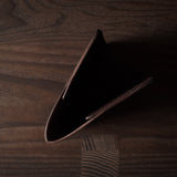 Brown leather passport case on a wooden surface