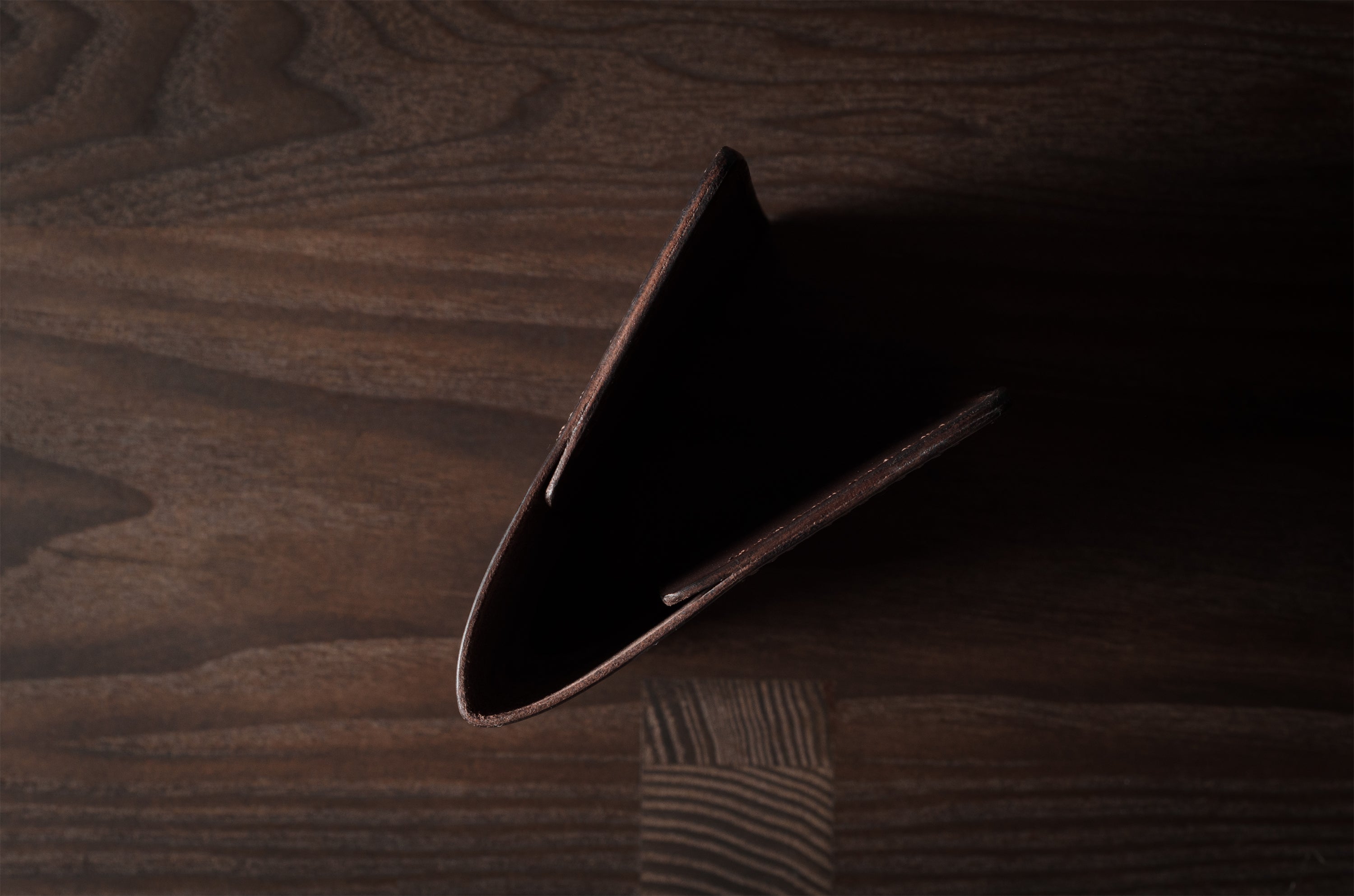Brown leather passport case on a wooden surface