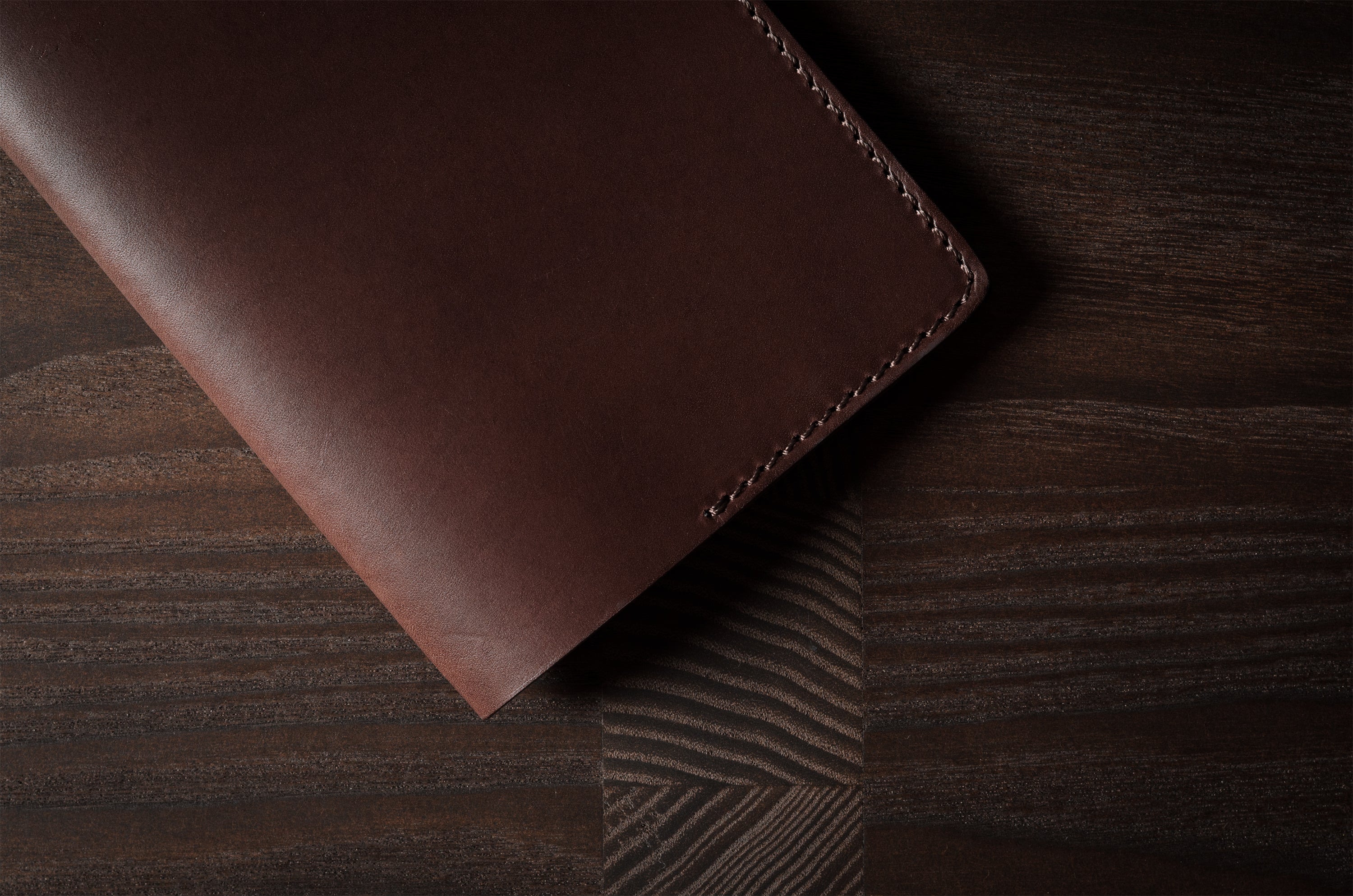 Brown leather passport case on a wooden surface