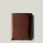 A brown leather iPhone Duo Case with a pebbled texture, shown closed against a solid light gray background.