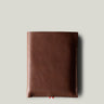 A brown leather iPhone Duo Case with a pebbled texture, shown closed against a solid light gray background.