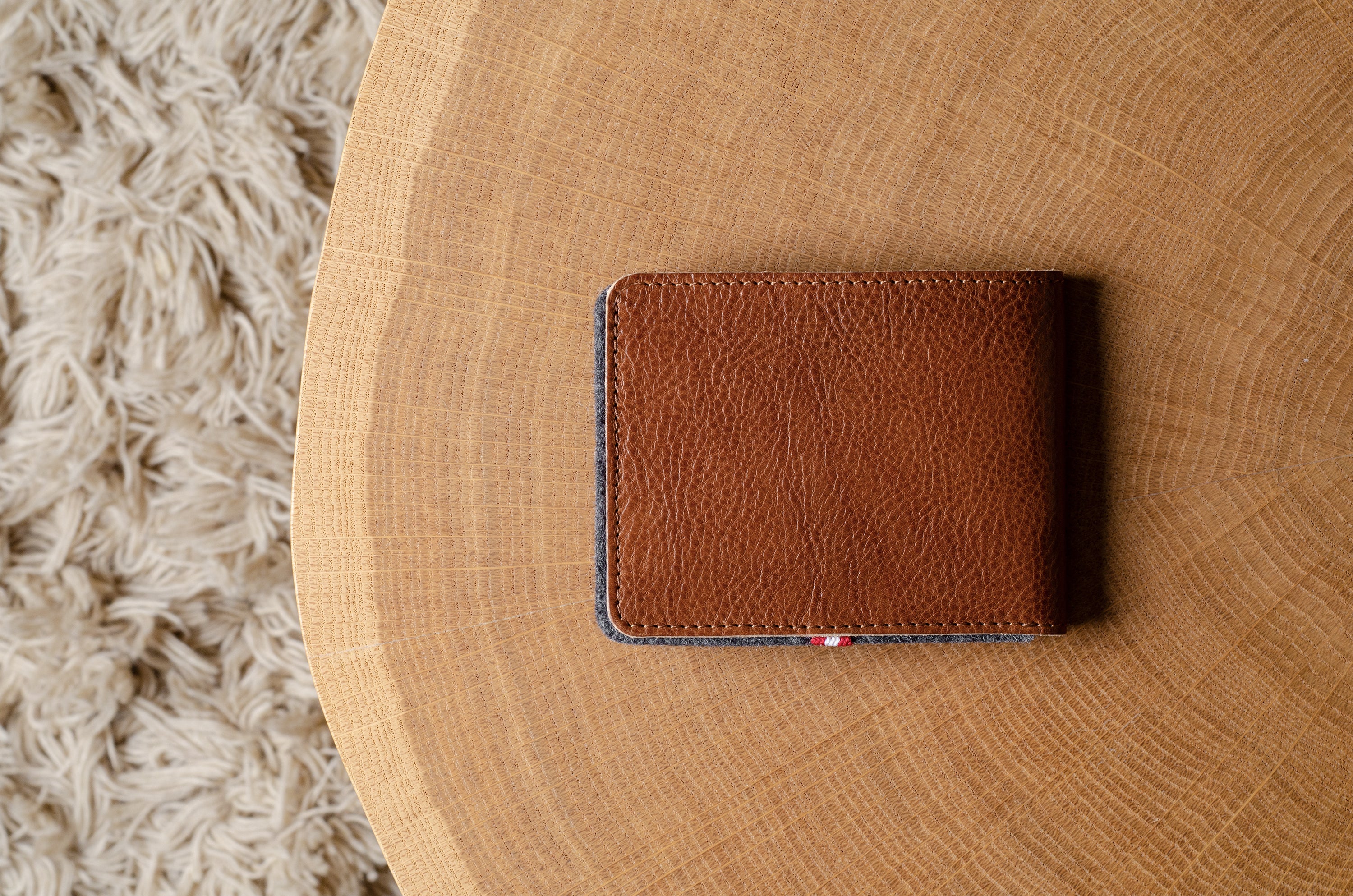 Brown leather bi-fold wallet  on a wooden surface