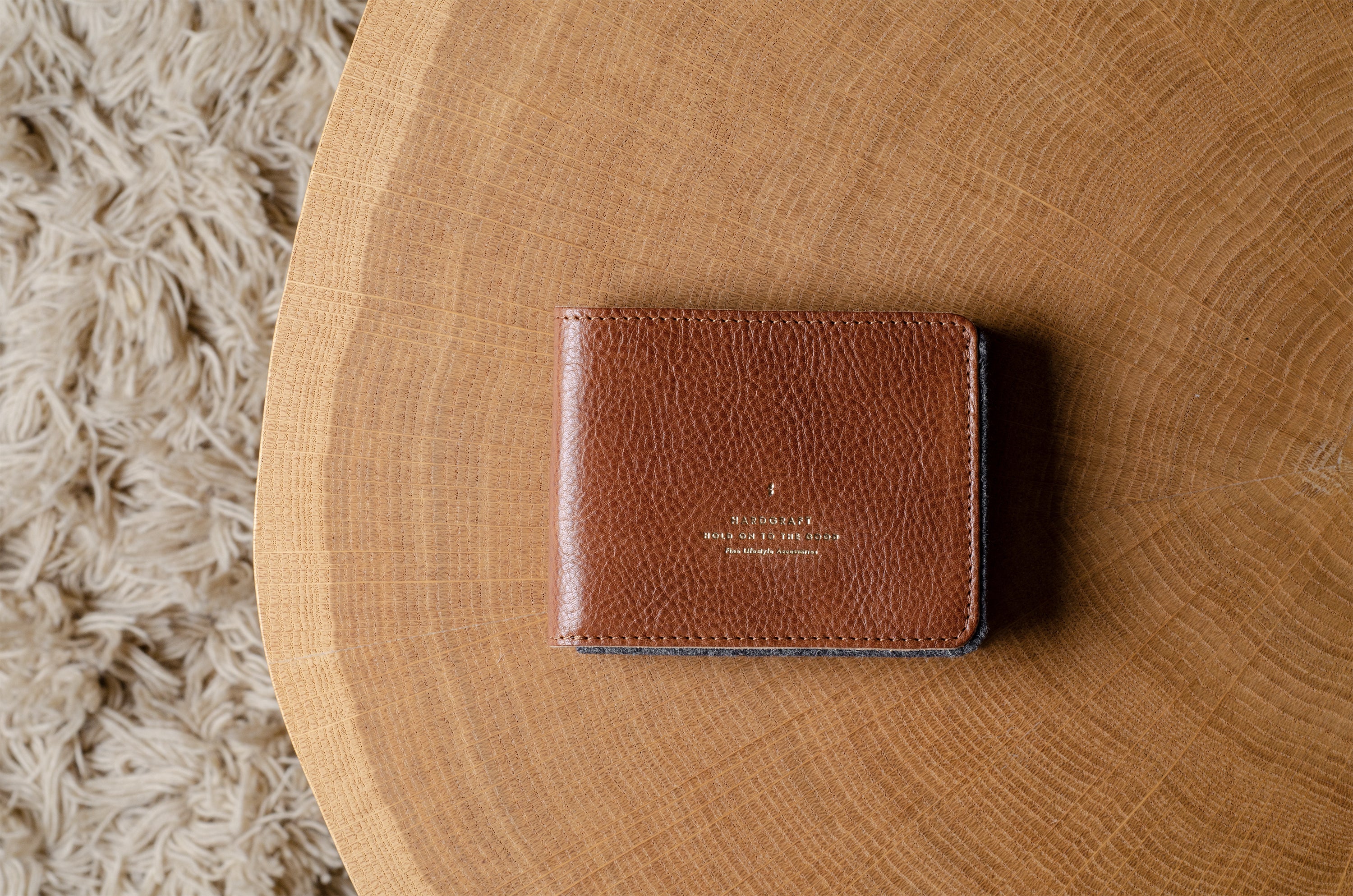 Brown leather bi-fold wallet  on a wooden surface