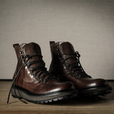 Pair of brown leather boots on a wooden floor with a neutral background