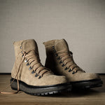 Pair of brown hiking boots on a wooden floor with a neutral background