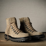 Pair of brown hiking boots on a wooden floor with a neutral background