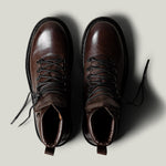 Brown leather hike boots on light grey background.