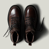Brown leather hike boots on light grey background.