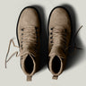 Pair of brown leather boots on a light gray background