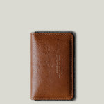 Brown leather wallet on a light gray background