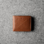 Brown leather wallet on a gray textured surface