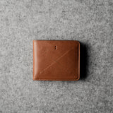 Brown leather wallet on a gray textured surface