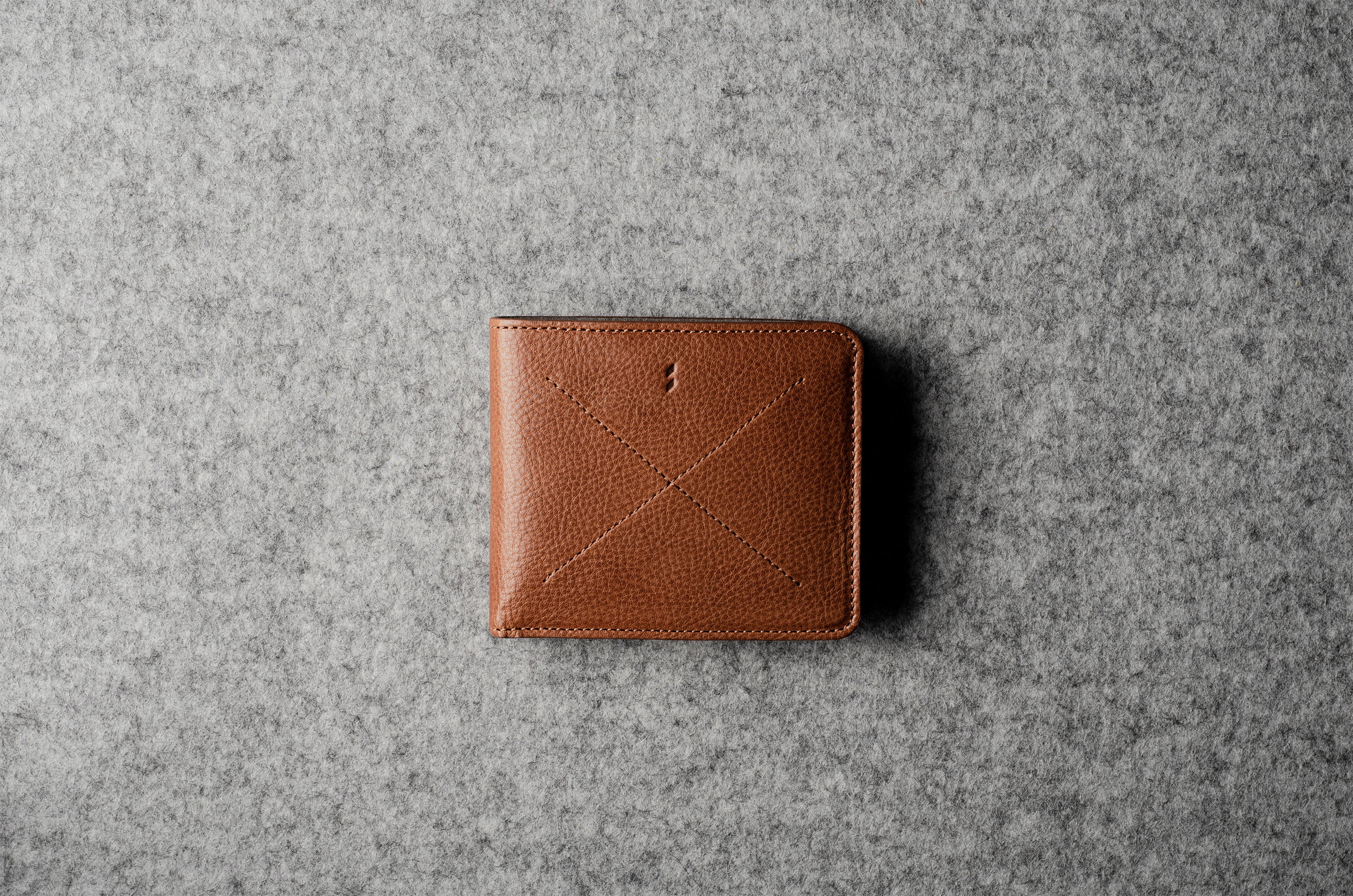 Brown leather wallet on a gray textured surface