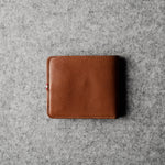 Brown leather wallet on a gray textured surface