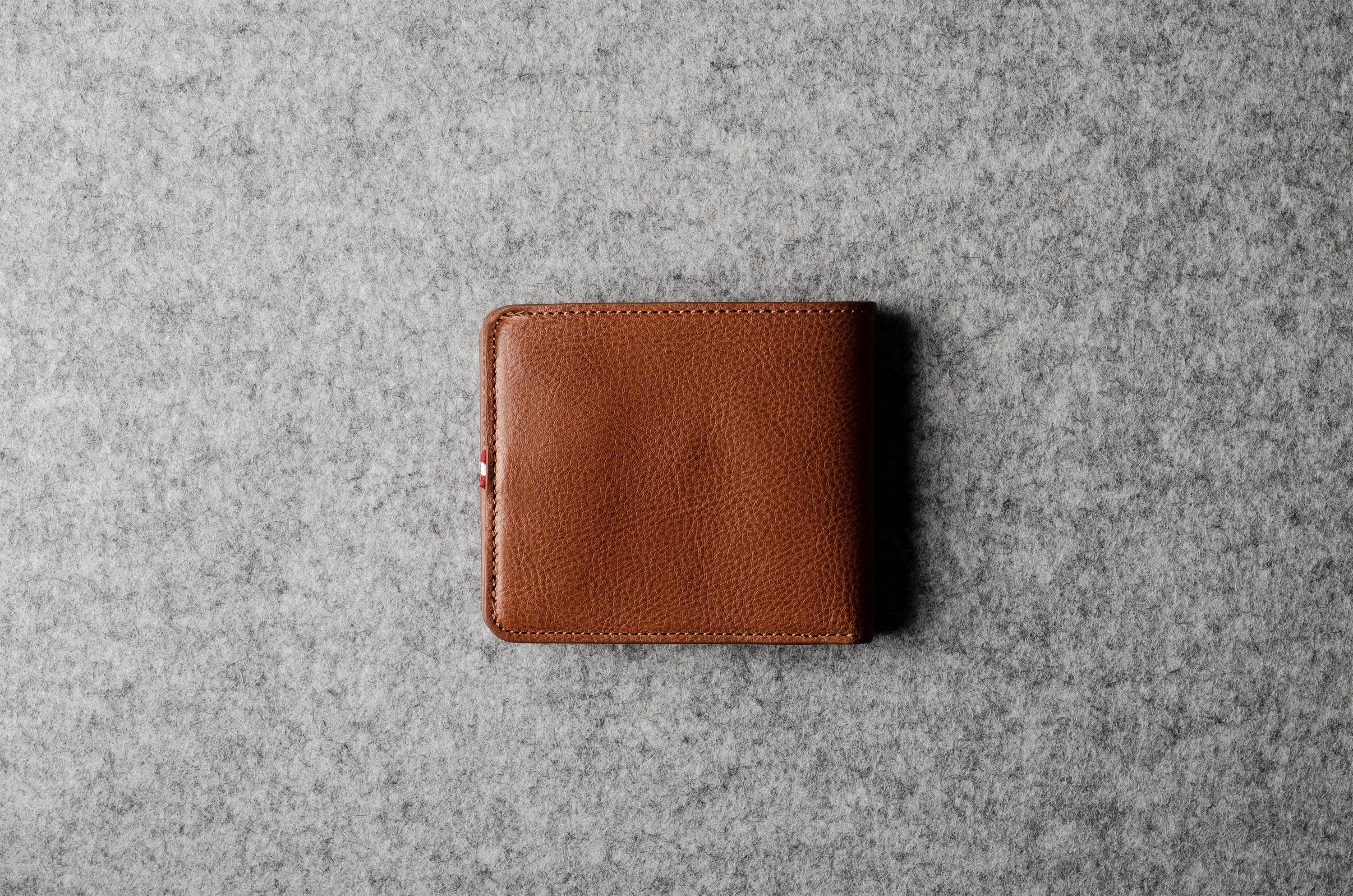 Brown leather wallet on a gray textured surface