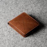 Brown leather wallet on a gray textured surface