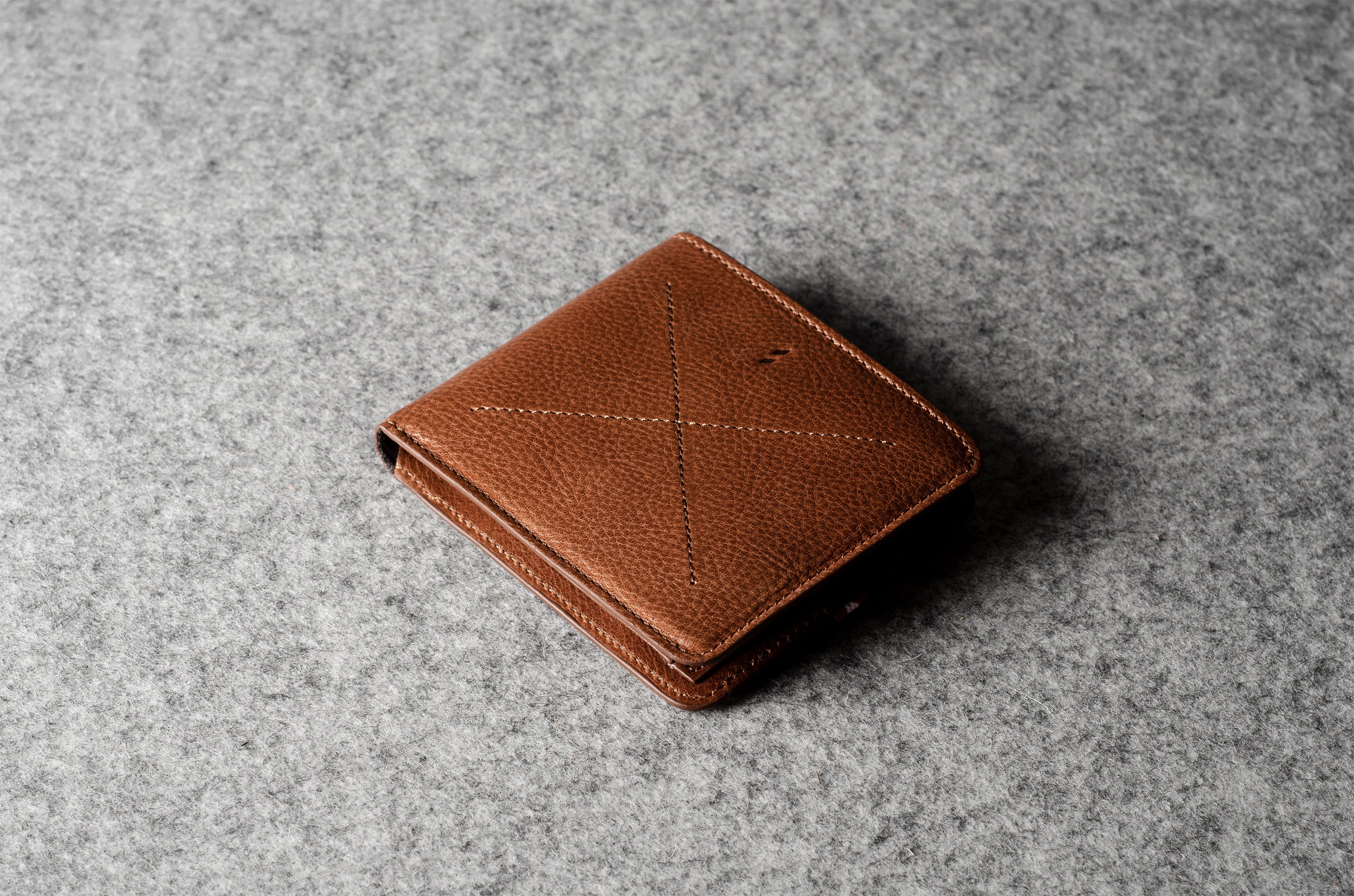 Brown leather wallet on a gray textured surface