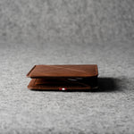 Brown leather wallet on a gray textured surface