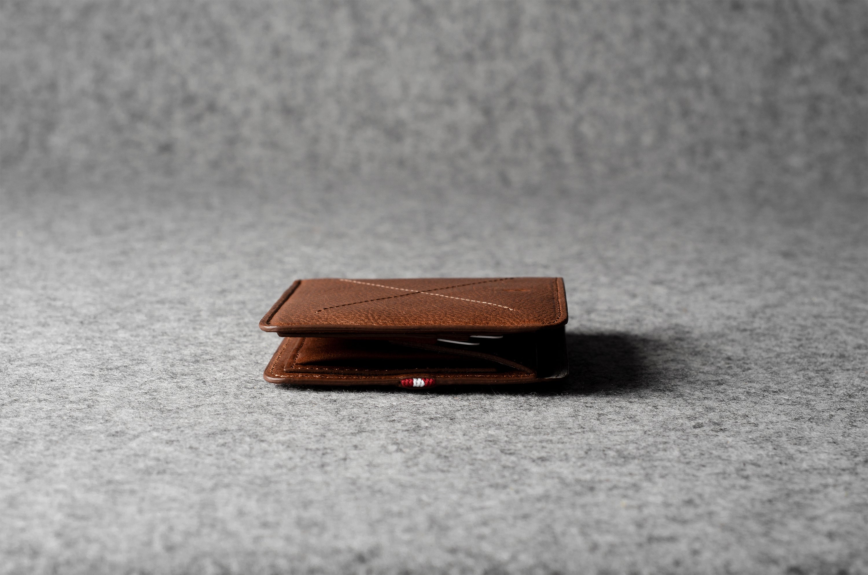 Brown leather wallet on a gray textured surface