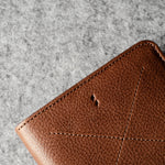 Brown leather wallet on a gray textured surface