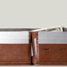 Brown leather wallet with card slots and money pocket on a light gray background