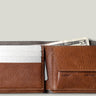 Brown leather wallet with money and cards on a light gray background