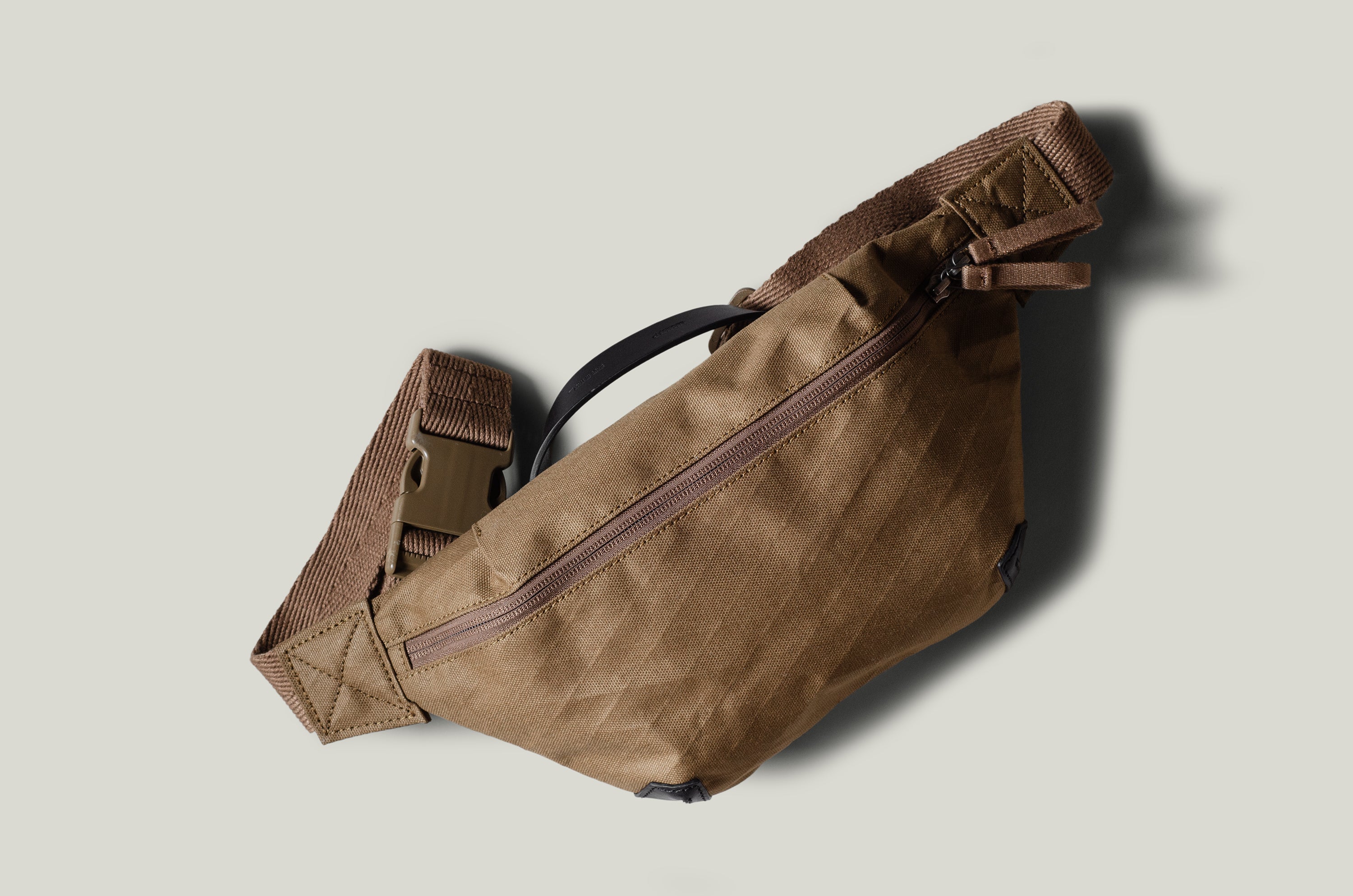 Brown waist cross body bag with technical fabric and brown leather details.