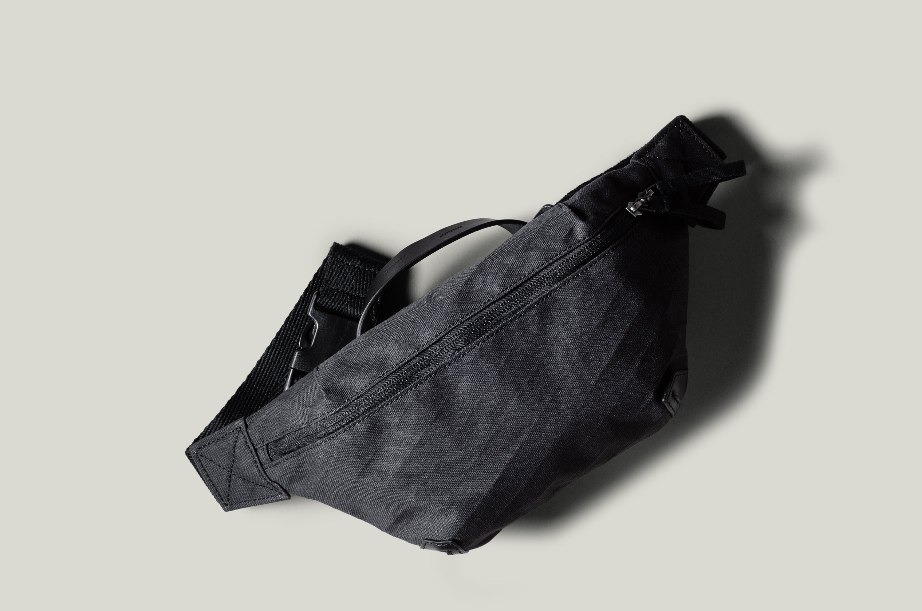 Black waist cross body bag with technical fabric and black leather details.