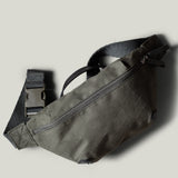 Green waist cross body bag with technical fabric and black leather details.