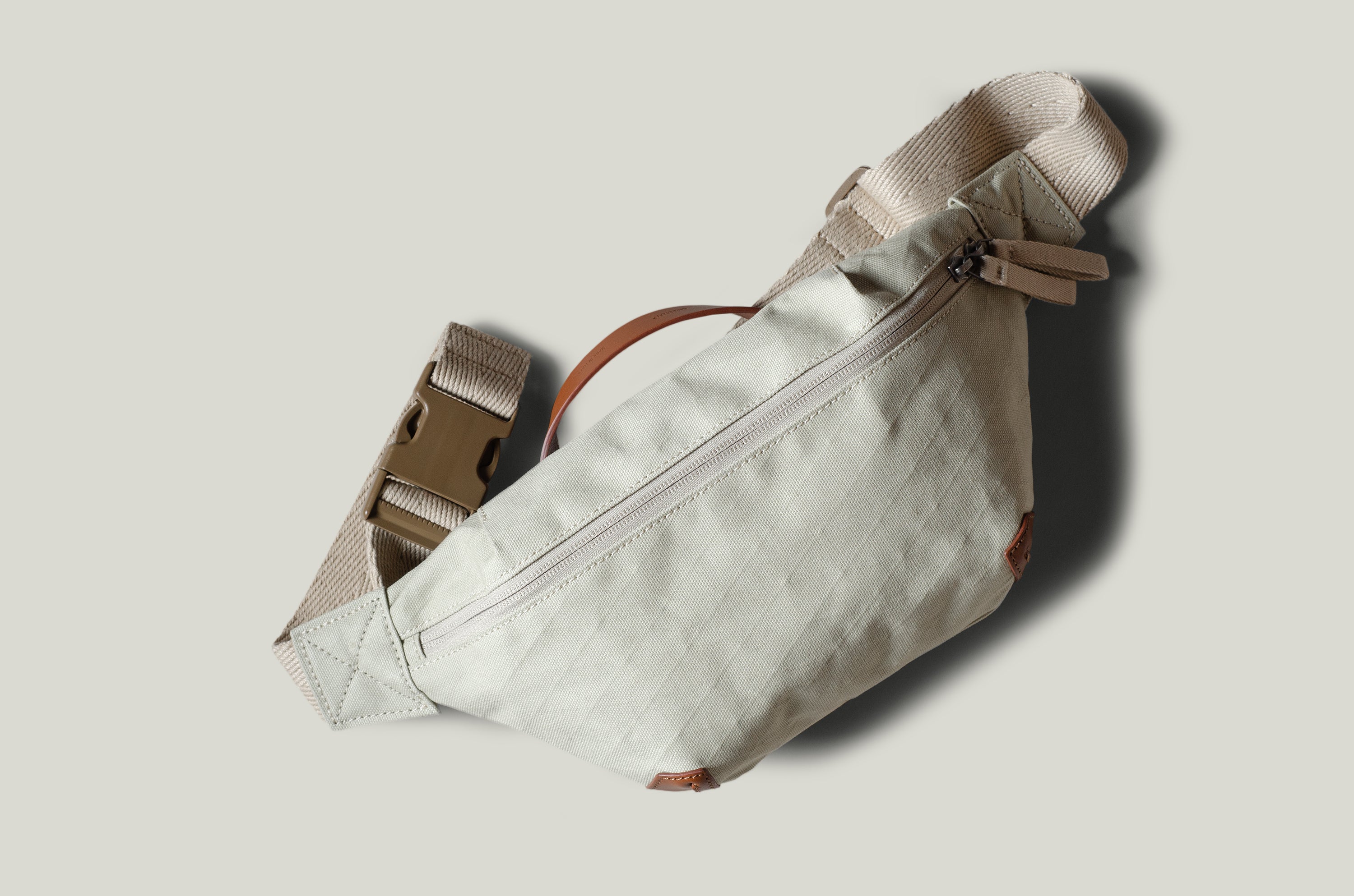 Beige waist cross body bag with technical fabric and brown leather details.