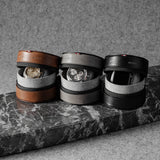 Three watch cases on a marble surface with a neutral background