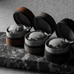 Three open leather watch cases on a marble surface