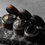 Set of three watch cases with watches on a marble surface