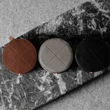 Three open leather watch cases on a marble surface