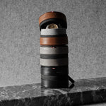 Stack of watch cases on a marble surface with a gray background