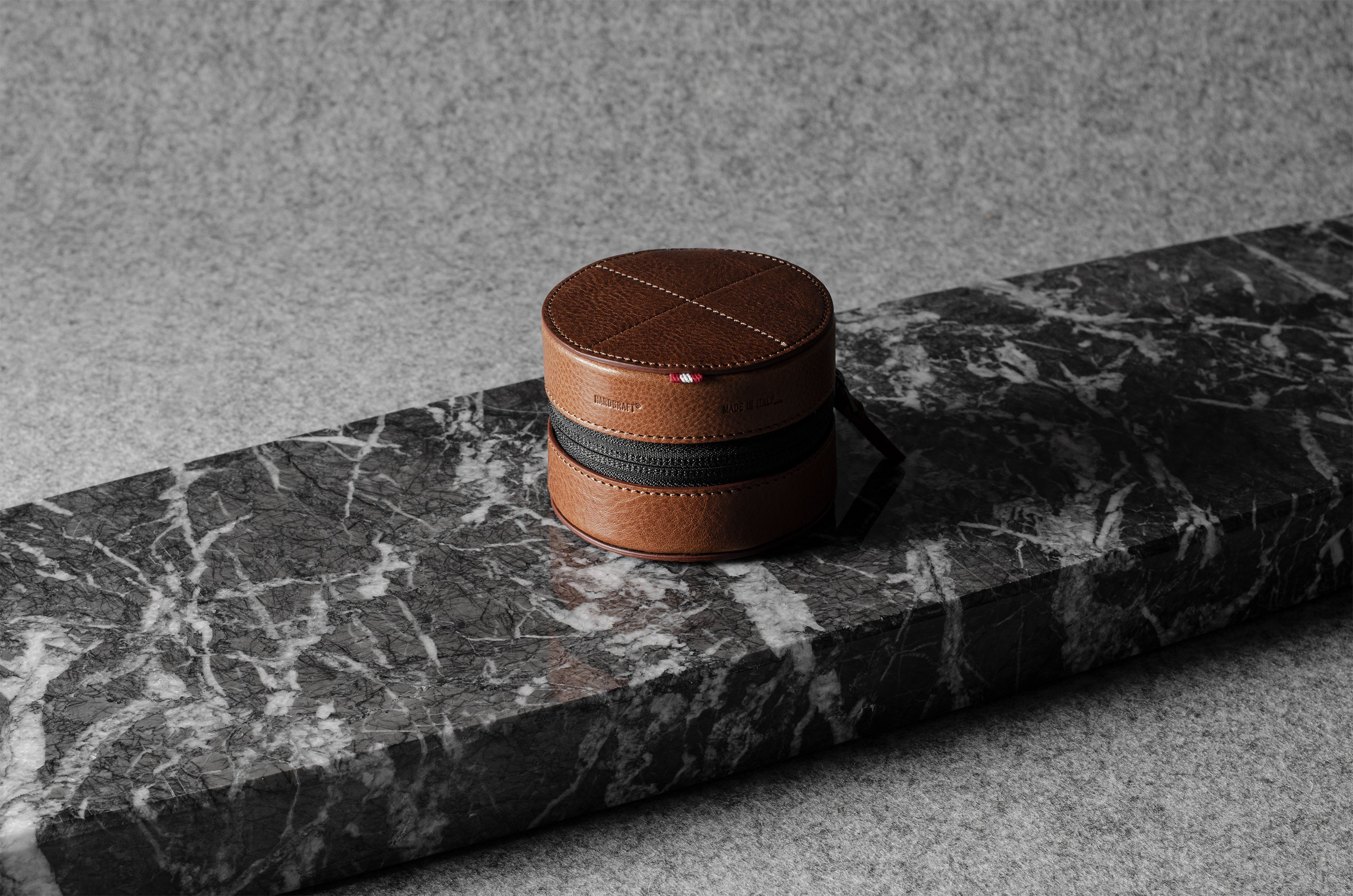 Brown leather watch case on a gray marble surface