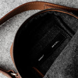 A classic brown leather shoulder bag with a zipper closure and an adjustable strap