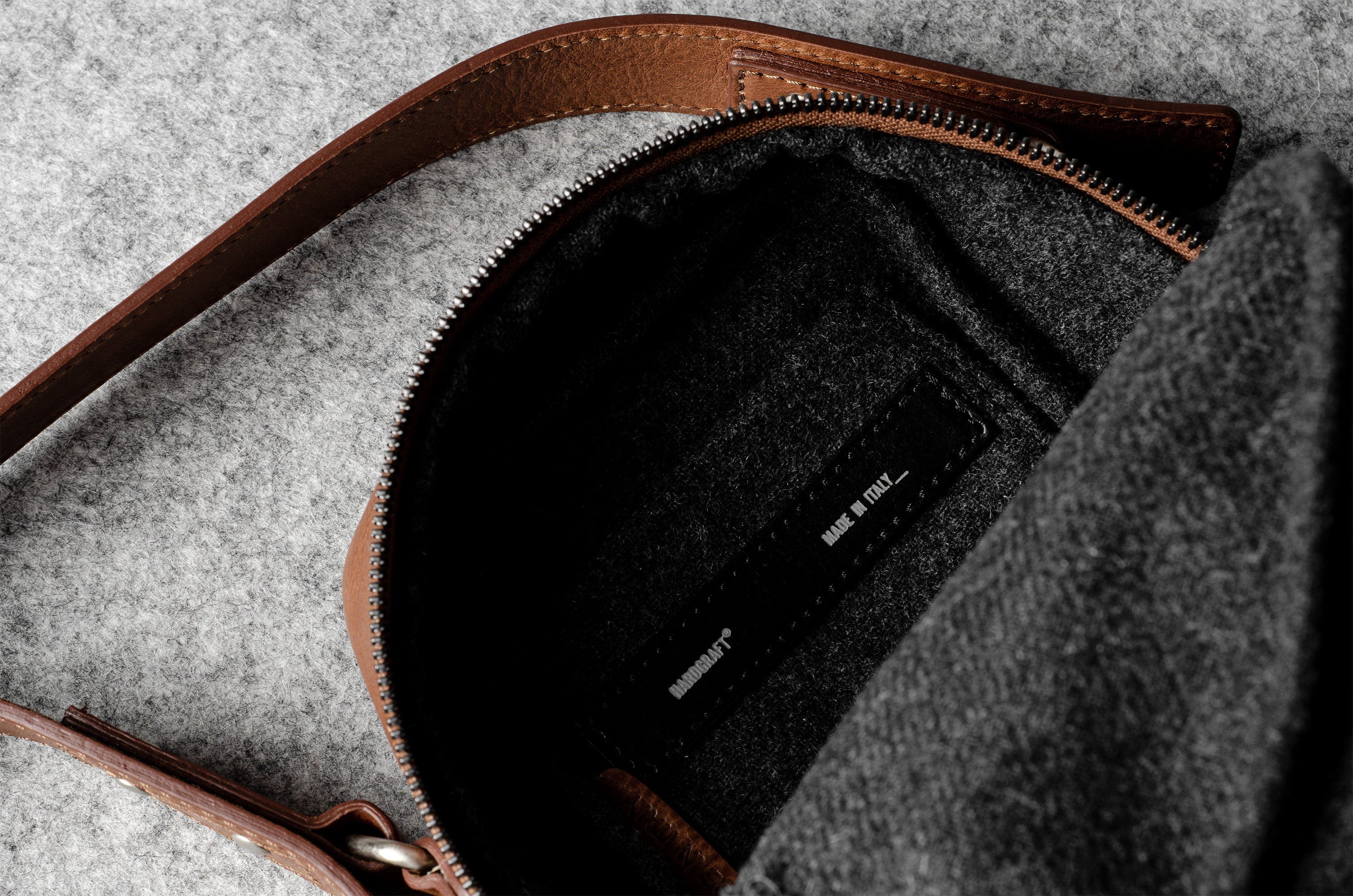 A classic brown leather shoulder bag with a zipper closure and an adjustable strap
