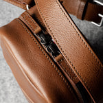 A classic brown leather shoulder bag with a zipper closure and an adjustable strap