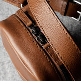 A classic brown leather shoulder bag with a zipper closure and an adjustable strap