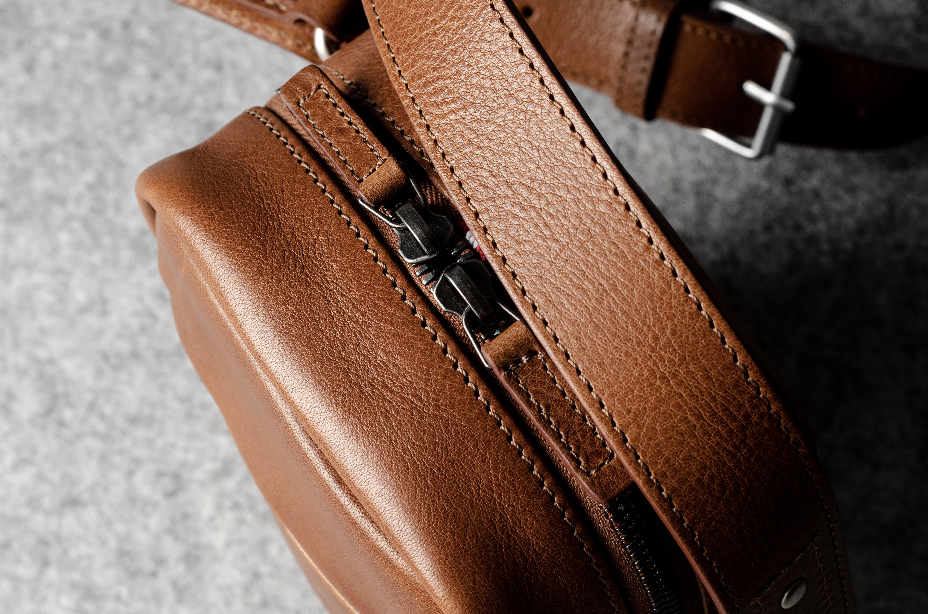 A classic brown leather shoulder bag with a zipper closure and an adjustable strap