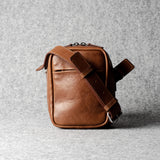 A classic brown leather shoulder bag with a zipper closure and an adjustable strap