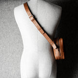 A classic brown leather shoulder bag with a zipper closure and an adjustable strap