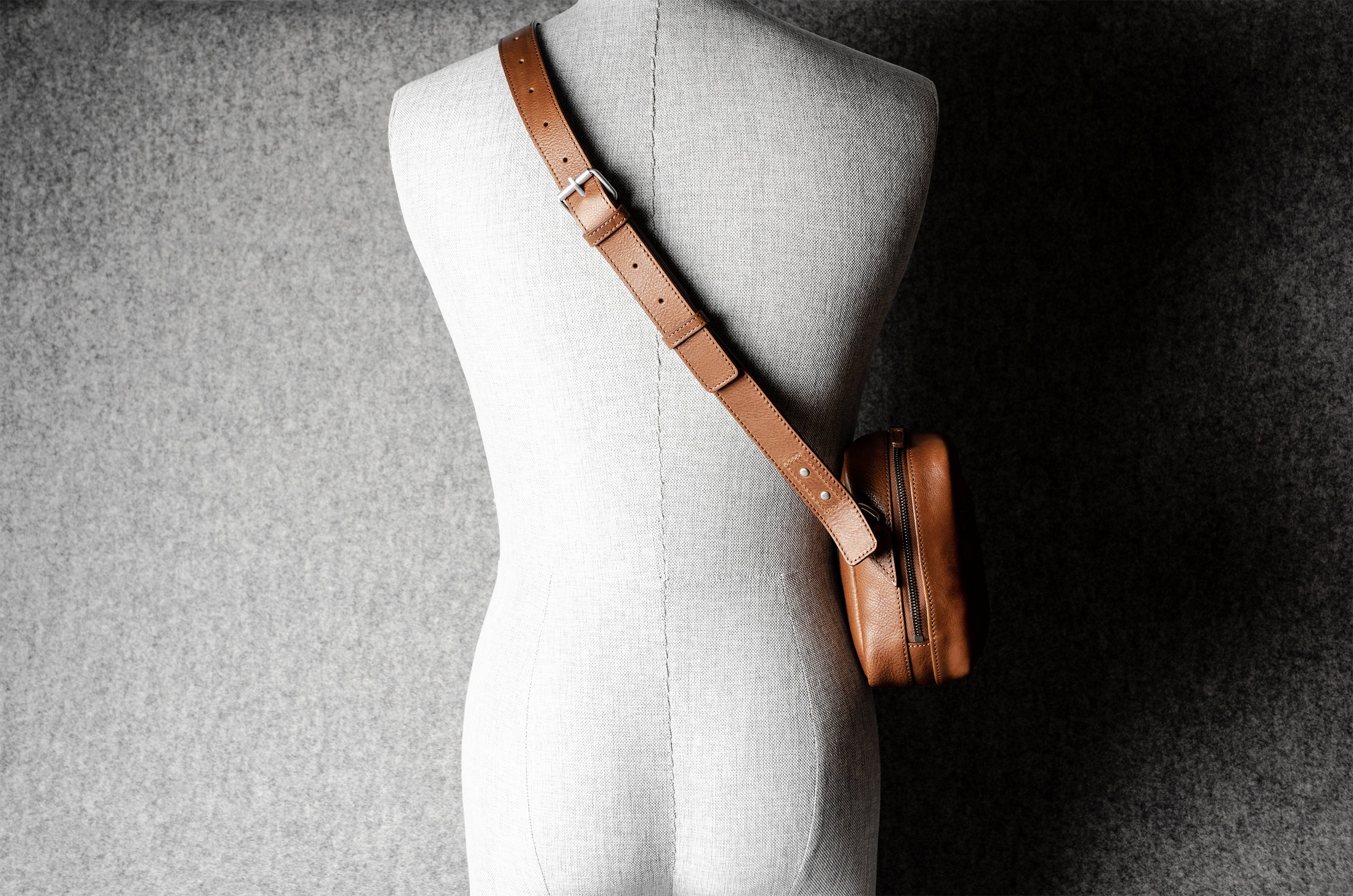 A classic brown leather shoulder bag with a zipper closure and an adjustable strap