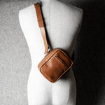 A classic brown leather shoulder bag with a zipper closure and an adjustable strap