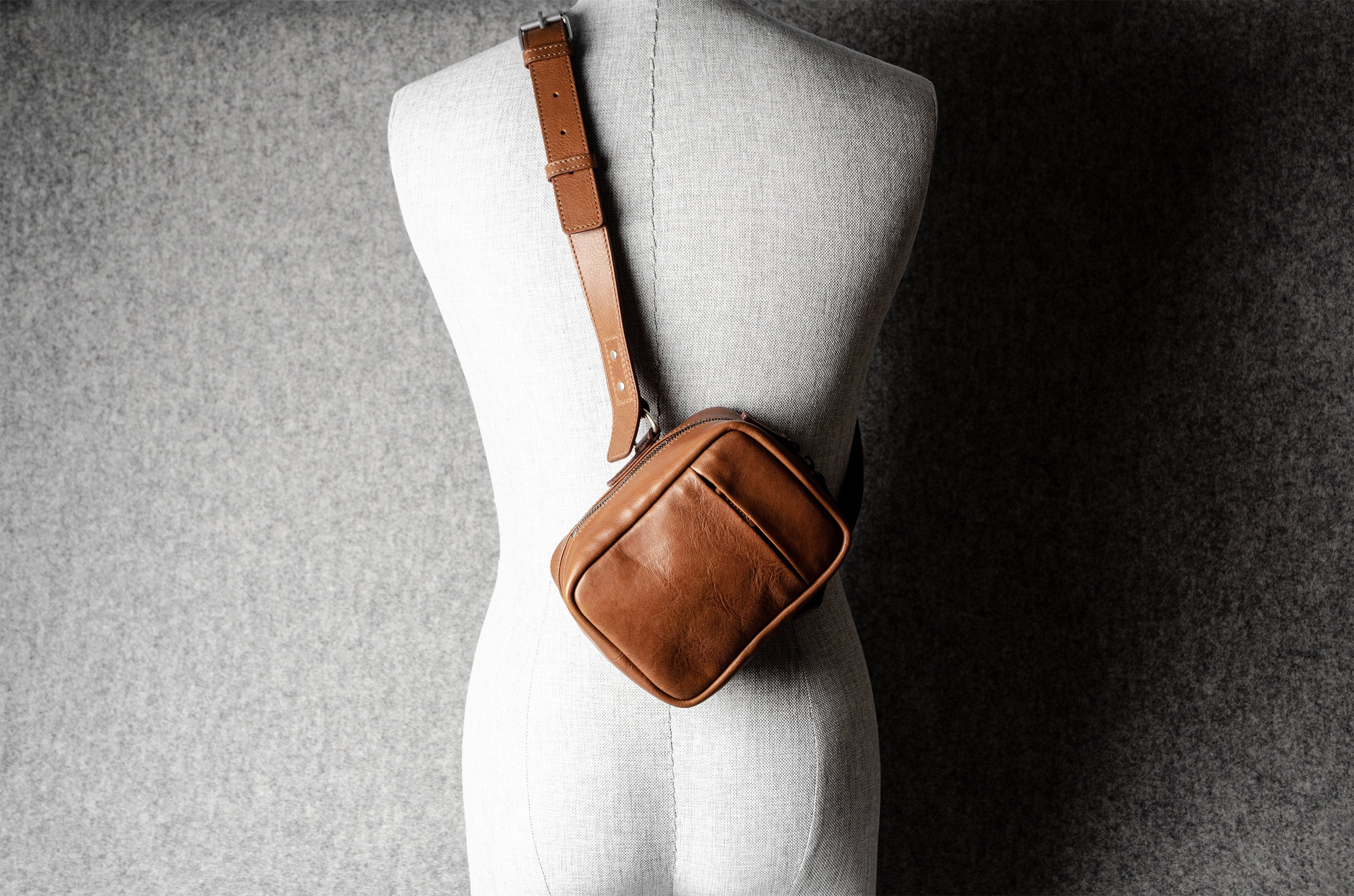 A classic brown leather shoulder bag with a zipper closure and an adjustable strap