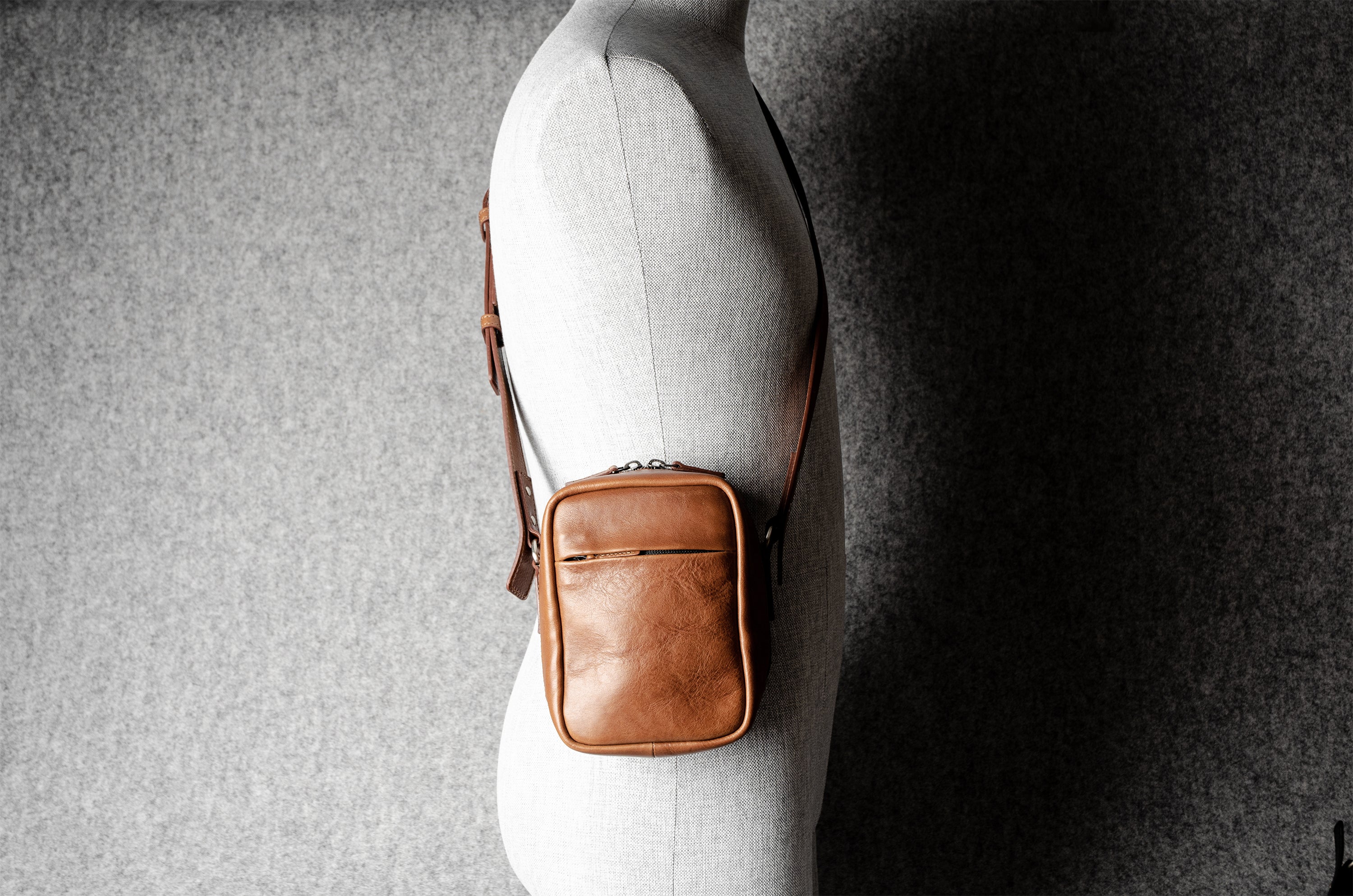 A classic brown leather shoulder bag with a zipper closure and an adjustable strap